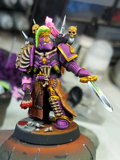An Emperor's Children converted marine painted purple with golden trim and bone covering with a non metallic metal down pointed sword