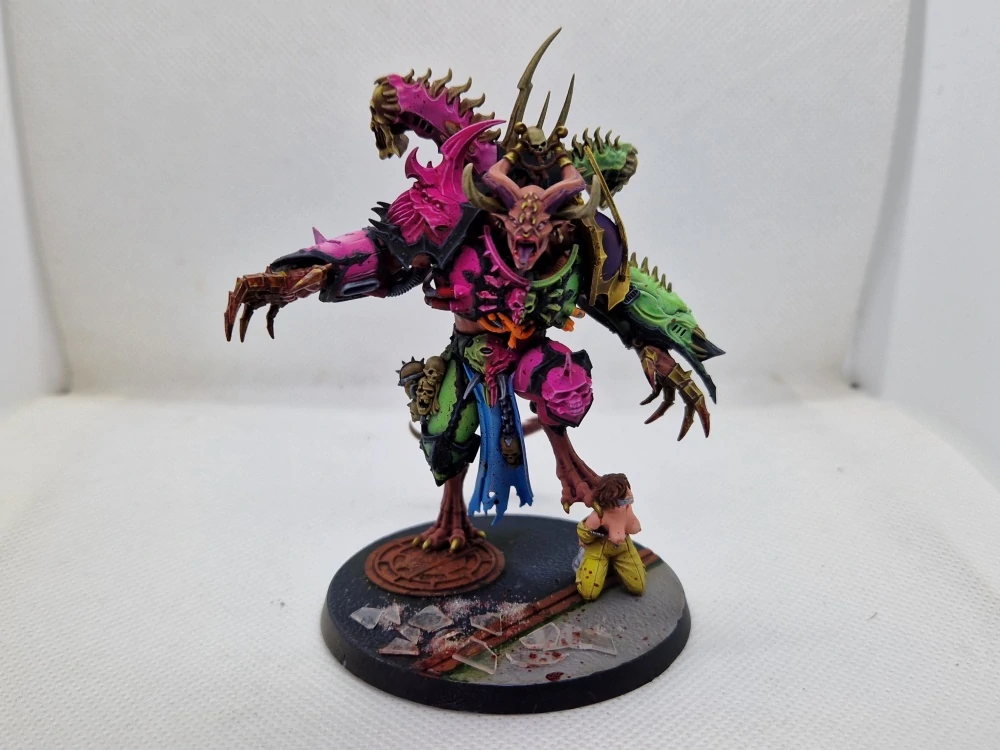 Emperor's Children daemon prince painted in garish colours to a high level with a female slave at his angle